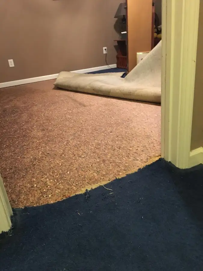 Carpet pad removal revealing water damage during Drying & Dehumidification in Fort Madison